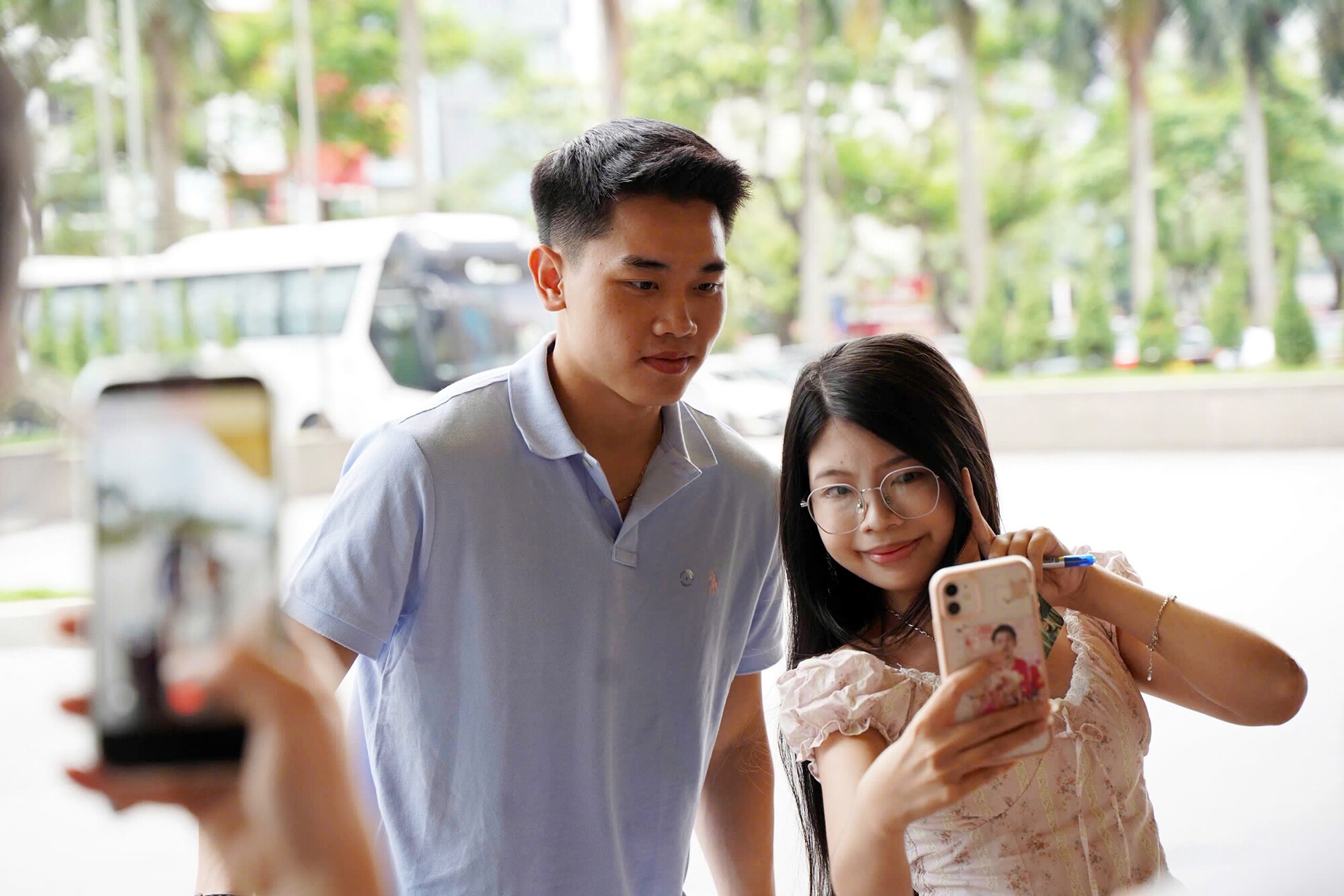Đình Bắc vui vẻ chụp ảnh với fan nữ bên ngoài khách sạn của ĐT Việt Nam.